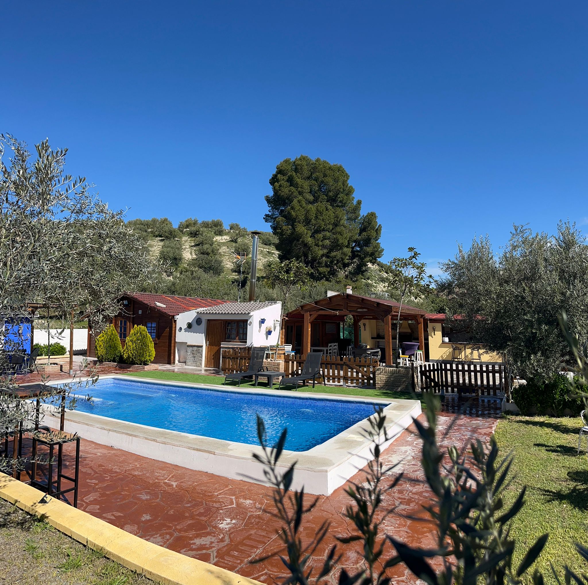 Vista general de la finca con piscina y montañas